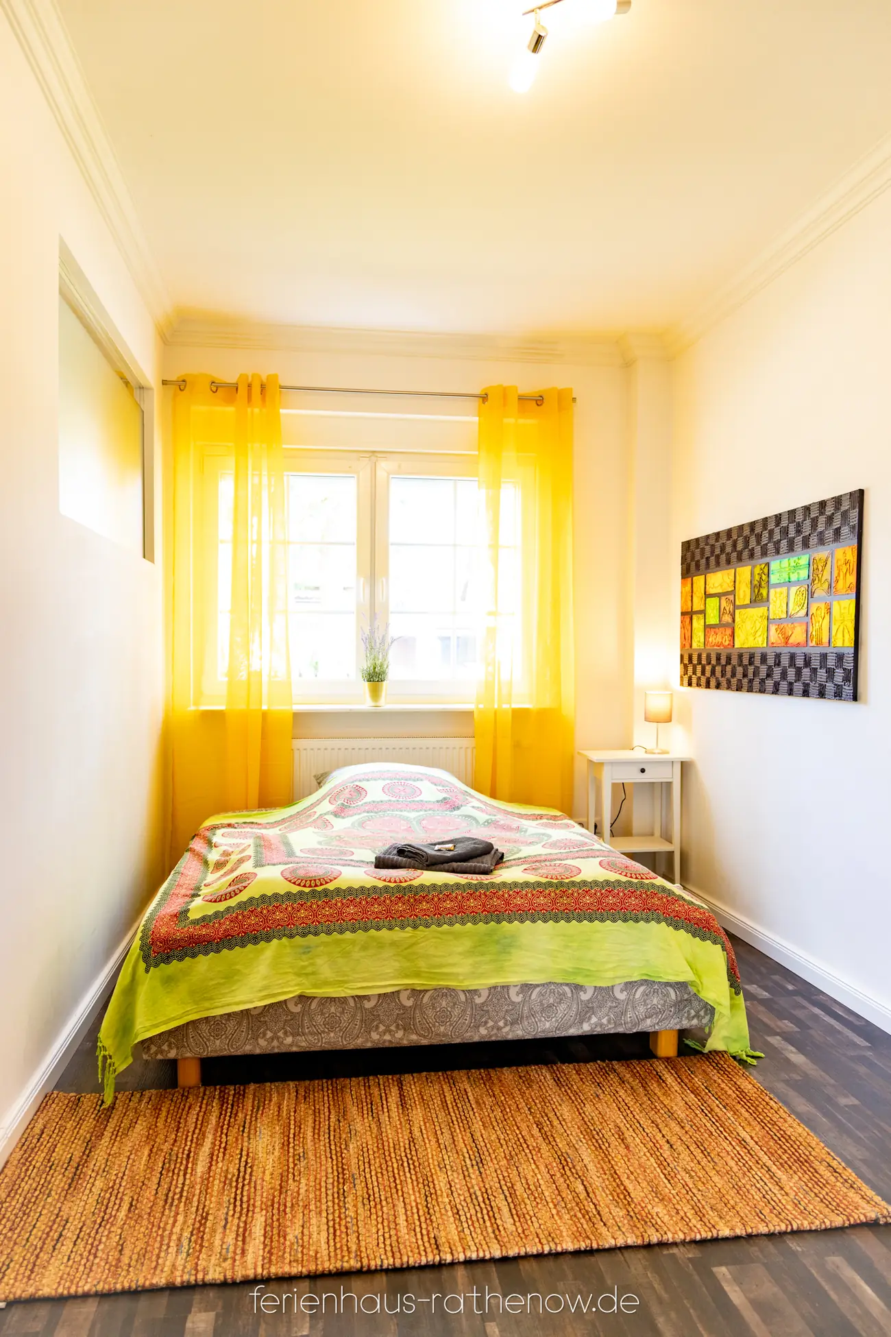 Schlafzimmer mit Doppelbett und hellen Vorhängen